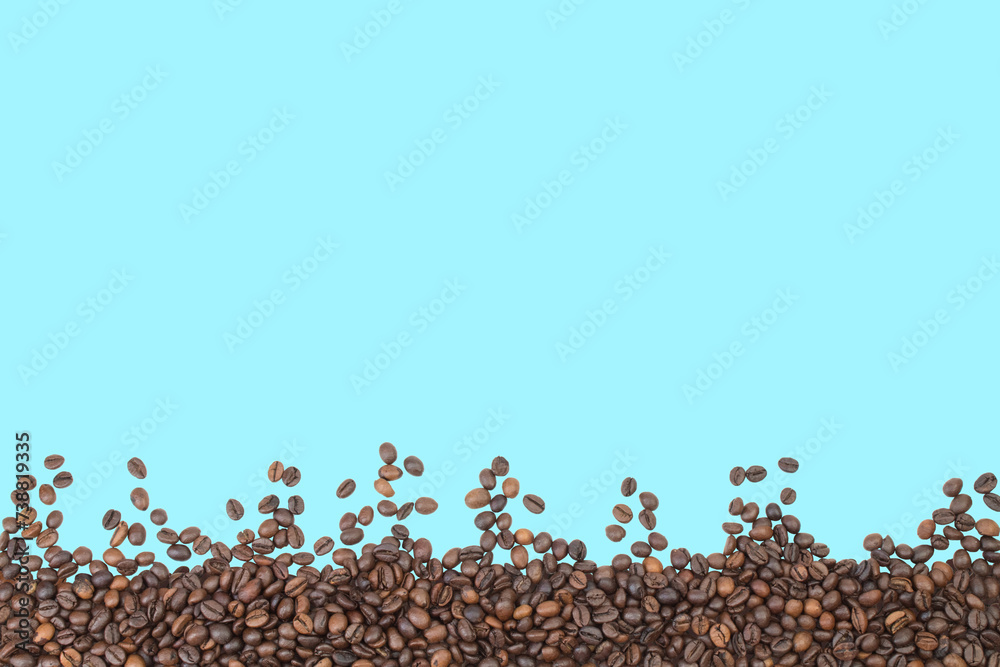 Fototapeta premium coffee beans isolated on blue background, border. Copy space for text.
