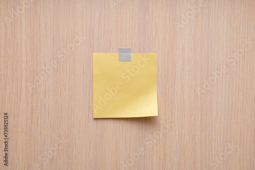 Yellow sticky note on wood