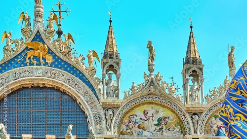 VENICE, ITALY - APRIL 25 2018: Detail of gable of Patriarchal Cathedral Basilica of Saint Mark showing patron apostle St. Mark with angels. Underneath is winged lion, symbol of saint and of Venice. photo