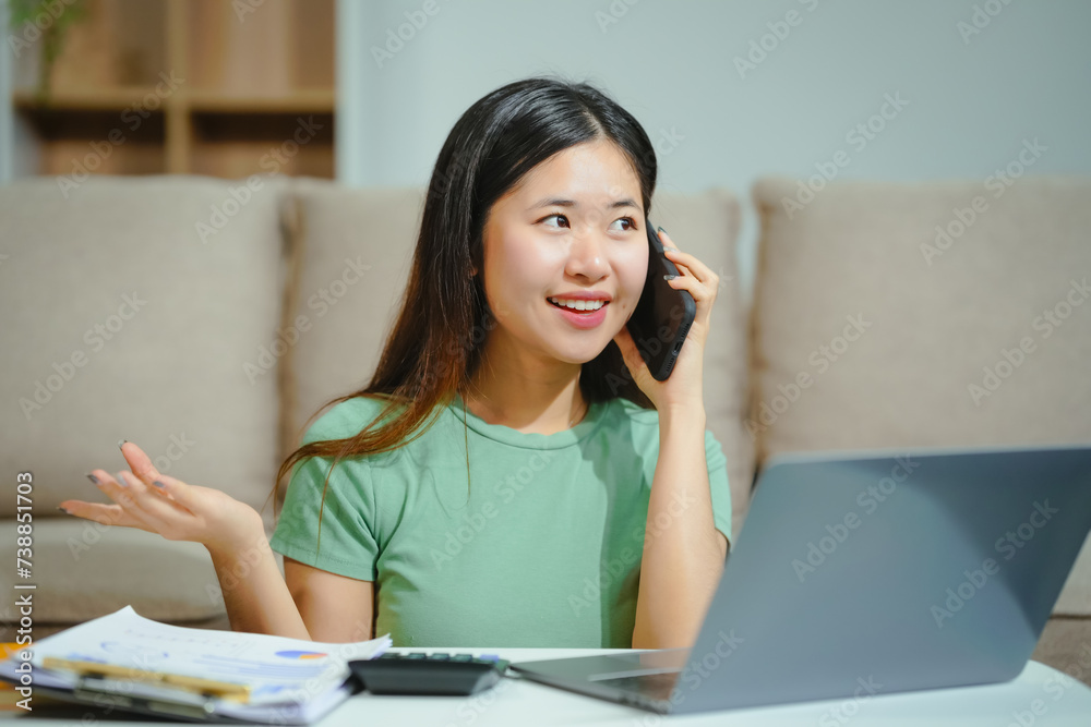 young Asian girl engages in online learning, doing homework on her sofa in the living room. video classes, combining comfort and education at home. young Asian girl engages in online learning, doing homework on her sofa in the living room. video classes, combining comfort and education at home.