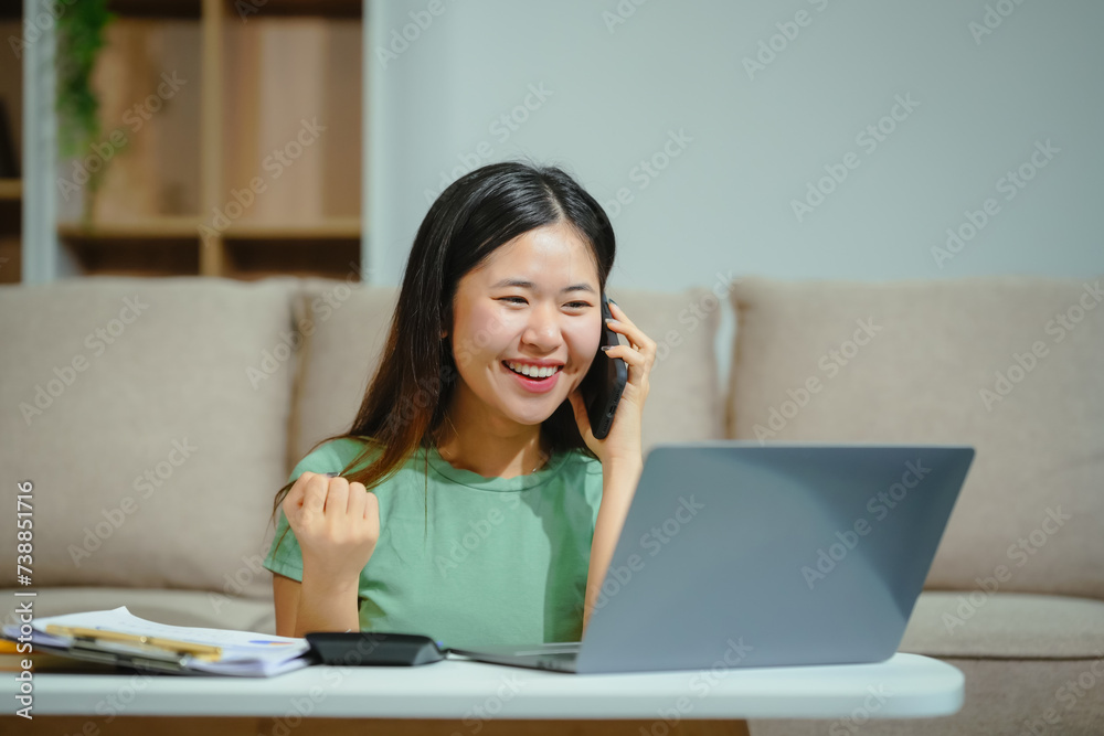 young Asian girl engages in online learning, doing homework on her sofa in the living room. video classes, combining comfort and education at home. young Asian girl engages in online learning, doing homework on her sofa in the living room. video classes, combining comfort and education at home.