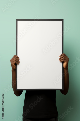 person holding up a white mockup frame in an office