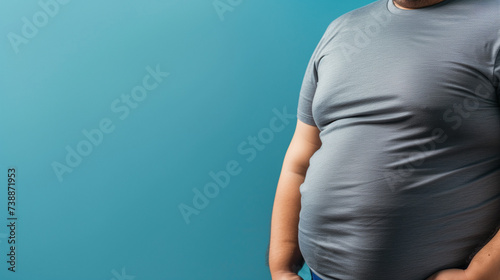 overweight man in tight t-shirt on a light blue background © The Stock Photo Girl