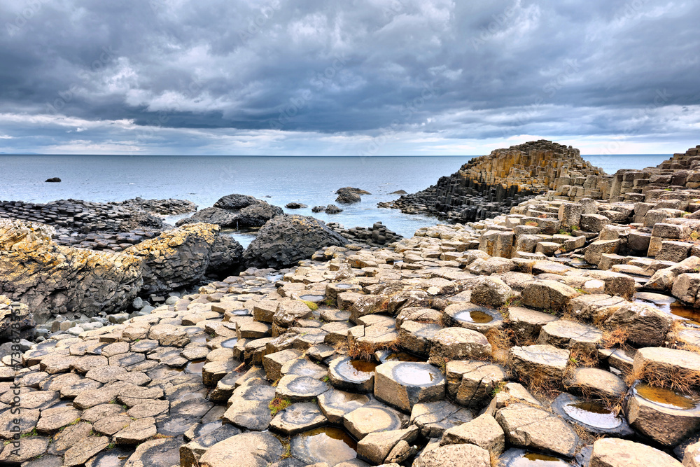 Beautiful rock formations of Giants Causeway under dramatic cloudy skies, Northern Ireland