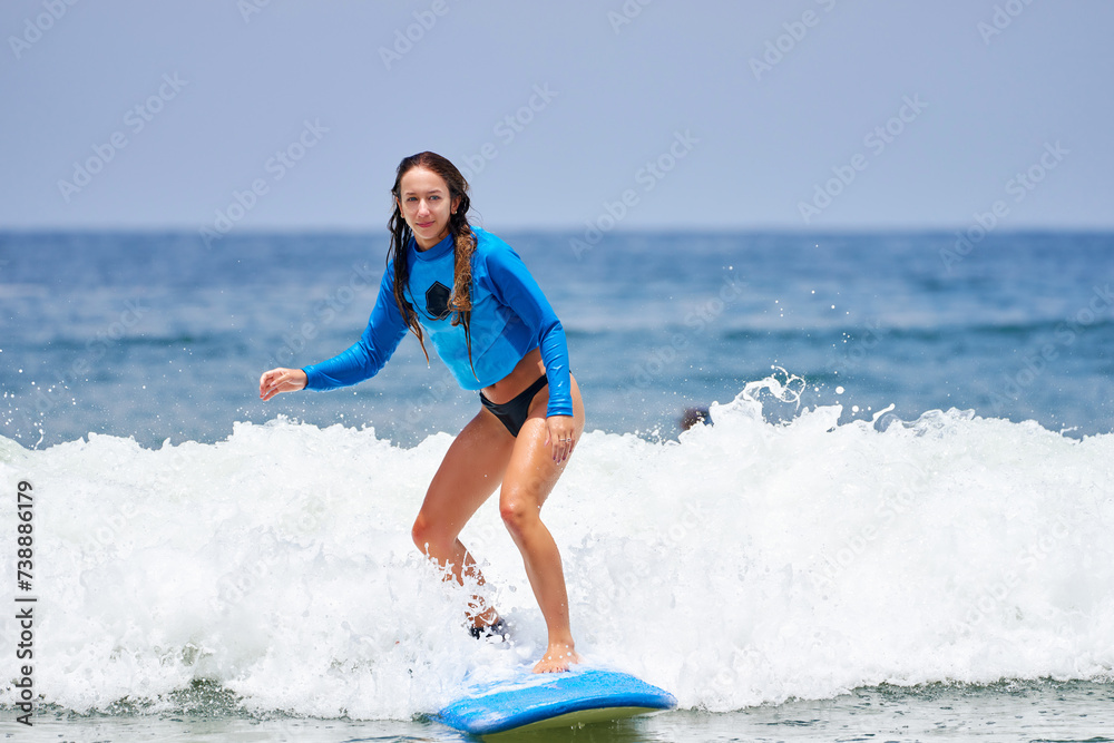 young woman learning to surf the waves young woman learning to surf the waves