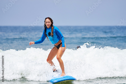 young woman learning to surf the waves
