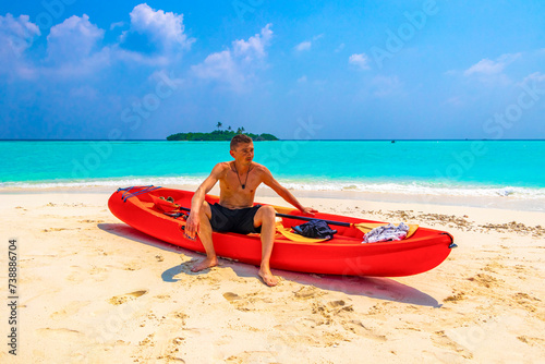 Fototapeta Naklejka Na Ścianę i Meble -  Tourist man kayaking canoe boat water on Rasdhoo island Maldives.