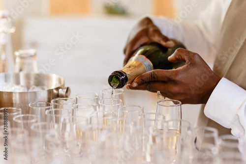 Serveur remplissant les flûtes de champagne photo
