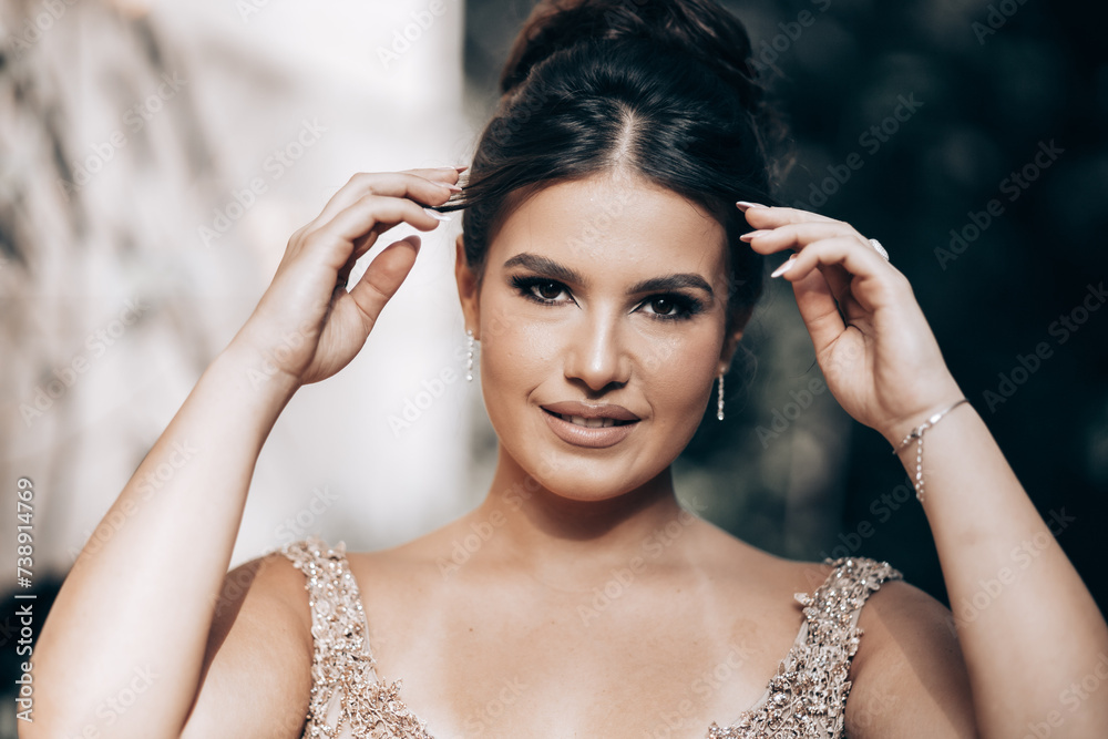 Obraz premium Close up portrait of a teen brunette girl in a golden dress. Ready for prom