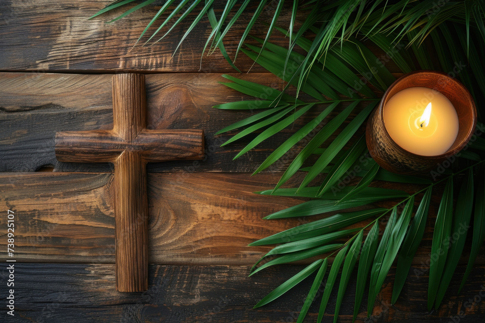 Fototapeta premium Christian wooden cross, candle and palm branches as a symbol of the coming of Jesus to Jerusalem
