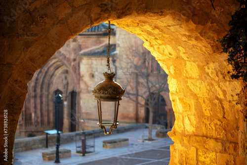 Street lamp under an arch in the Plaza Monumental de Alcaraz, Albacete, Castilla la Mancha, Spain, with golden early morning light photo