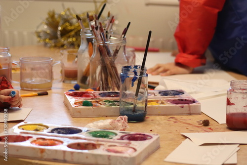 children with brushes. Children paint with paint.