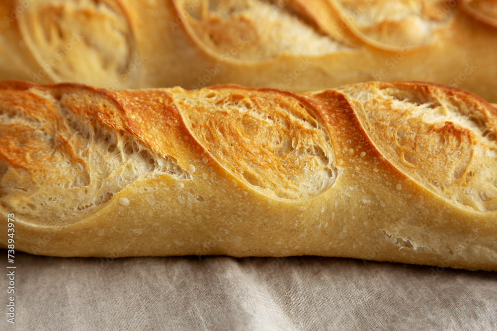 Homemade French Bread Baguette on cloth, side view.