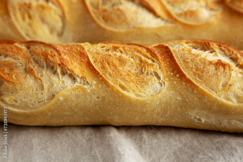 Homemade French Bread Baguette on cloth, side view.