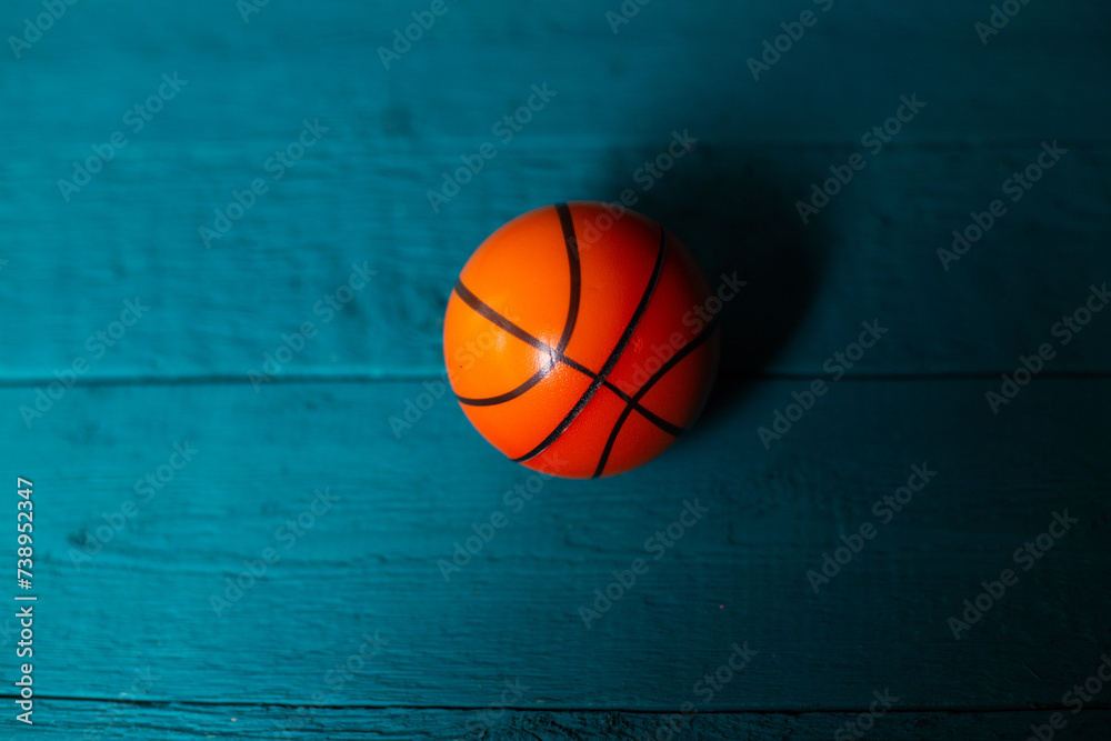 Toy basketball on a blue wooden background