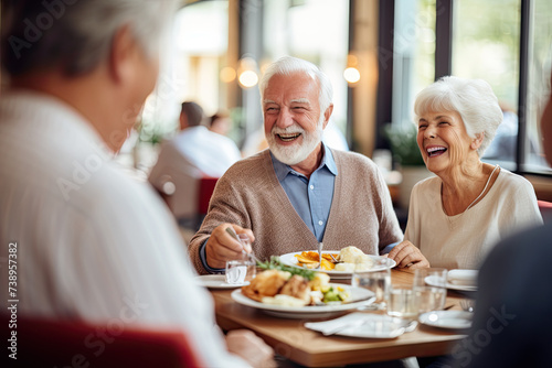 Laughing senior couples enjoying meal at restaurant.