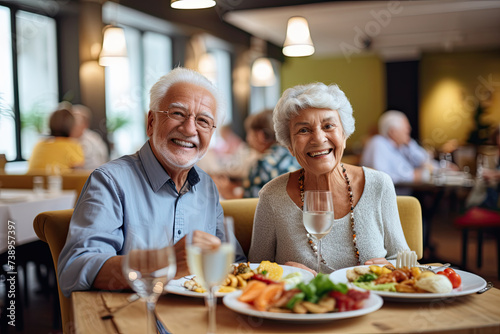 Laughing senior couples enjoying meal at restaurant.