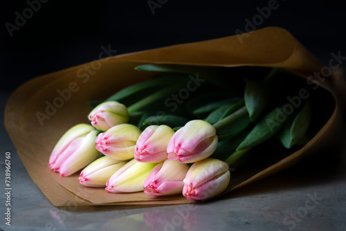 Fototapeta Naklejka Na Ścianę i Meble -  Beautiful buoquet of pink and yellow tulips on a table with brown craft paper 