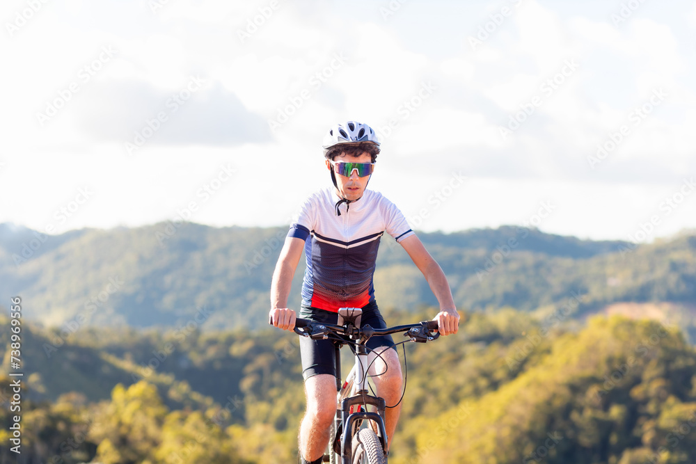 Brazilian cyclist riding his bike in the mountains. He's wearing Cycling Clothing and exercising on an outdoor trail
