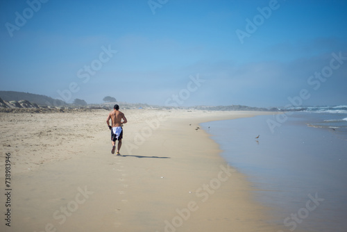 a man running on the send during a sunny day