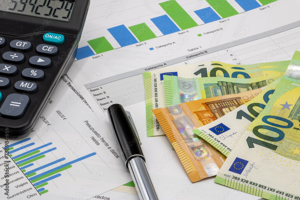 Calculator on finance graphs and euro bills Calculator on finance graphs and euro bills