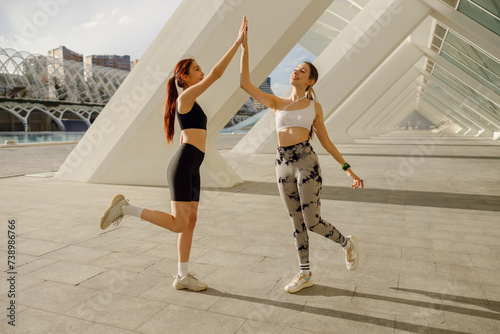 Sporty women greeting together outdoor doing gesture of shake hand after exercising
