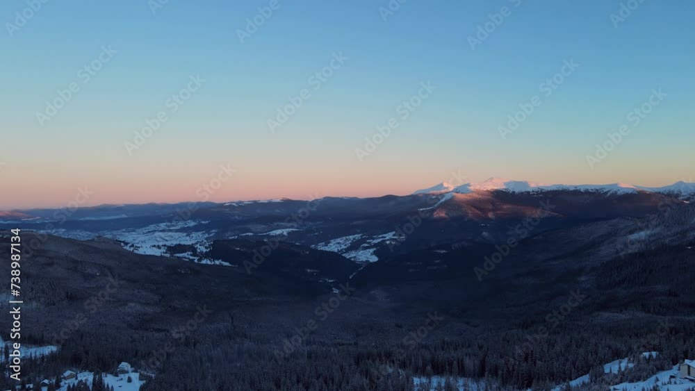 Sunset in the snowy winter mountains. View from a drone. Sunset in the snowy winter mountains. View from a drone.