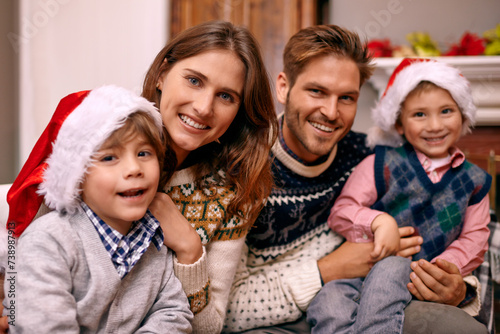 Christmas, portrait and happy family in home for holiday or festive celebration in lounge. Xmas, parents and face of children with hats in living room, bonding and kids together at party in house