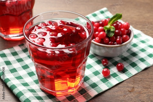 Tasty cranberry juice in glass and fresh berries on wooden table, closeup
