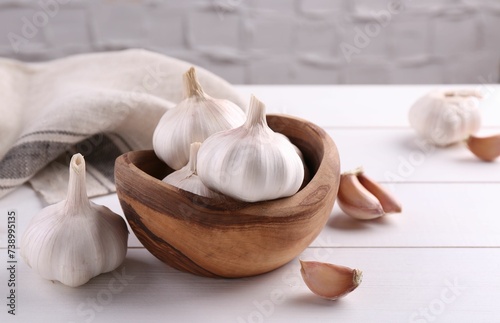 Fresh garlic on white wooden table, closeup. Space for text