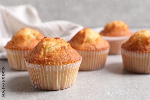 Tasty muffins on light grey table, closeup. Fresh pastry