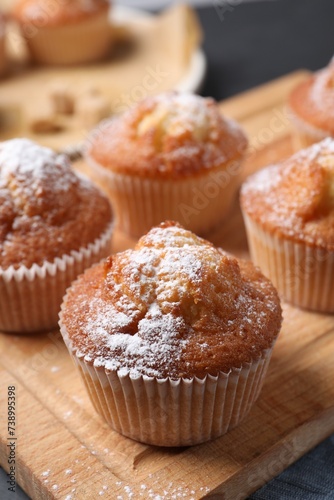 Delicious sweet muffins on wooden board, closeup