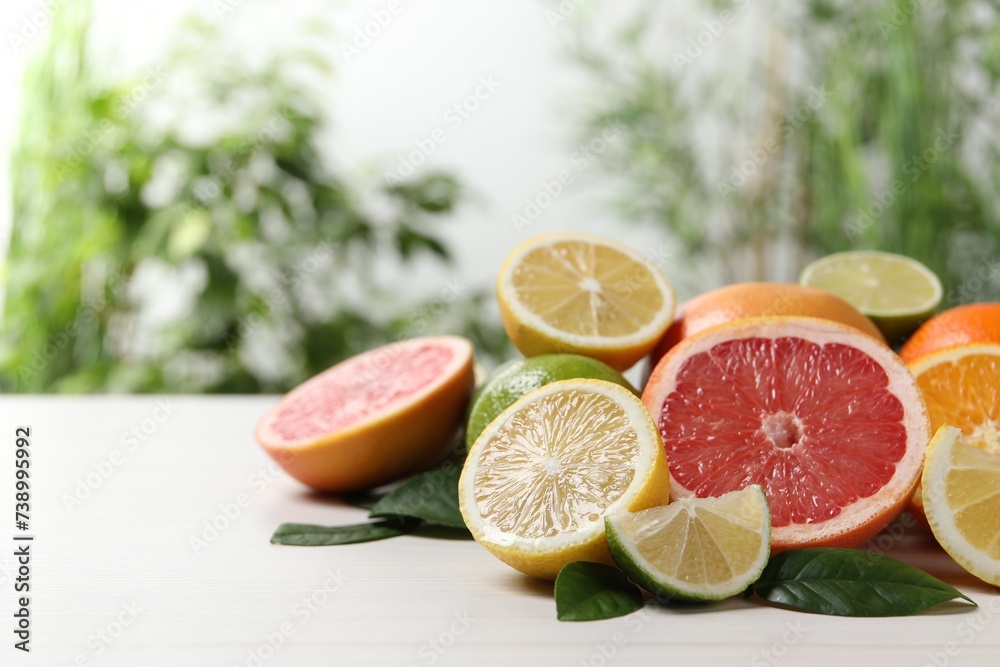 Different cut and whole citrus fruits on white wooden table. Space for text Different cut and whole citrus fruits on white wooden table. Space for text