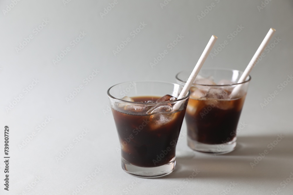 Refreshing iced coffee in glasses on grey background. Space for text Refreshing iced coffee in glasses on grey background. Space for text