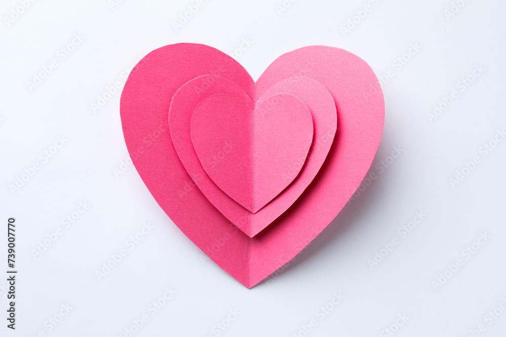 Pink paper hearts on white background, top view