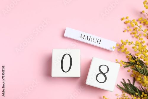 International Women's day - 8th of March. Wooden block calendar and beautiful flowers on pink background, flat lay