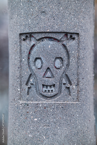 stamped skull an bones danger sign on electric concrete pole