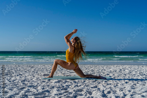 A Gorgeous Blonde Fit Model Practices Yoga On A White Sand Beach In The Early Morning