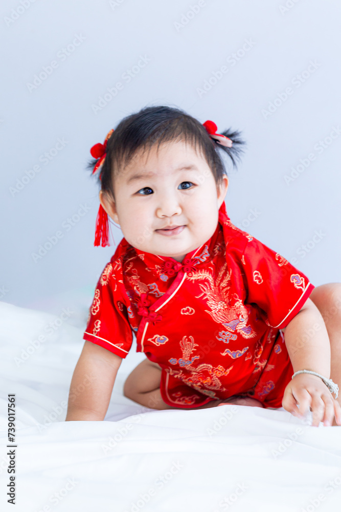 Chinese New Year concept, cute happy little girl in Chinese dress sitting in white living room. Cute Asian baby sitting in white living room, Chinese New Year concept Chinese New Year concept, cute happy little girl in Chinese dress sitting in white living room. Cute Asian baby sitting in white living room, Chinese New Year concept