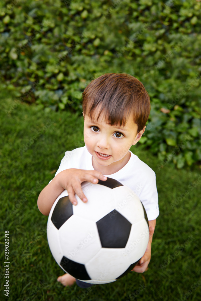 Portrait, boy or play with soccer ball in park for fun, healthy or childhood development in Morocco. Happy, young and male child with football for afternoon game or exercise in backyard or garden