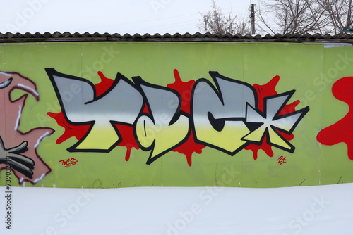 The old wall decorated with paint stains in the style of street art culture. Colorful background of full graffiti painting artwork with bright aerosol outlines on wall. Colored background texture