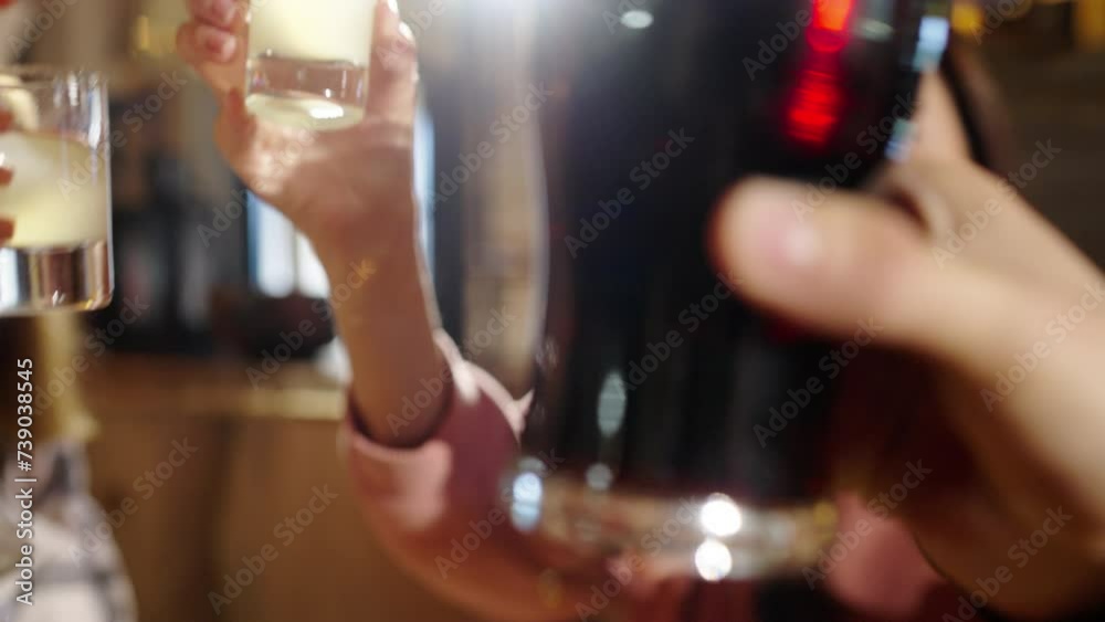 Group of happy multiethnic friends having fun together, drinking bottled beer in a bar or at home, celebrating, happily smiling - friendship, togetherness concept. Young people cheers alcohol drinks