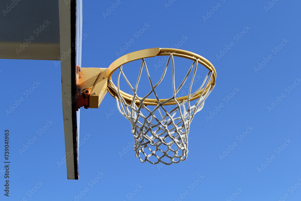 Basketball hoop and backboard against a blue sky background