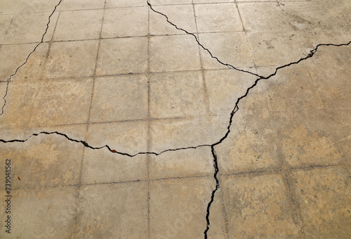 View of a patio's cracked cement due to ground settling below.