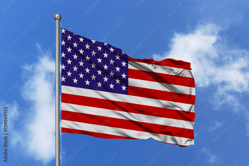 United States flag fluttering in the wind on sky.