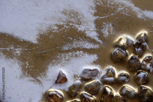acercamiento a piedras decorativas recubiertas con resina epóxica pigmentada con polvo dorado photo