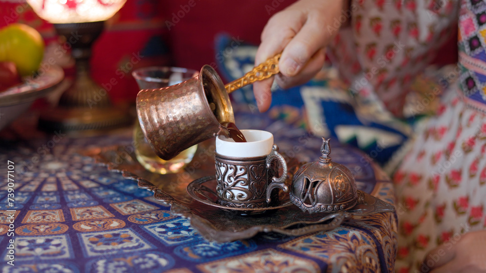 Obraz premium Pouring turkish coffee from cezve into cup.