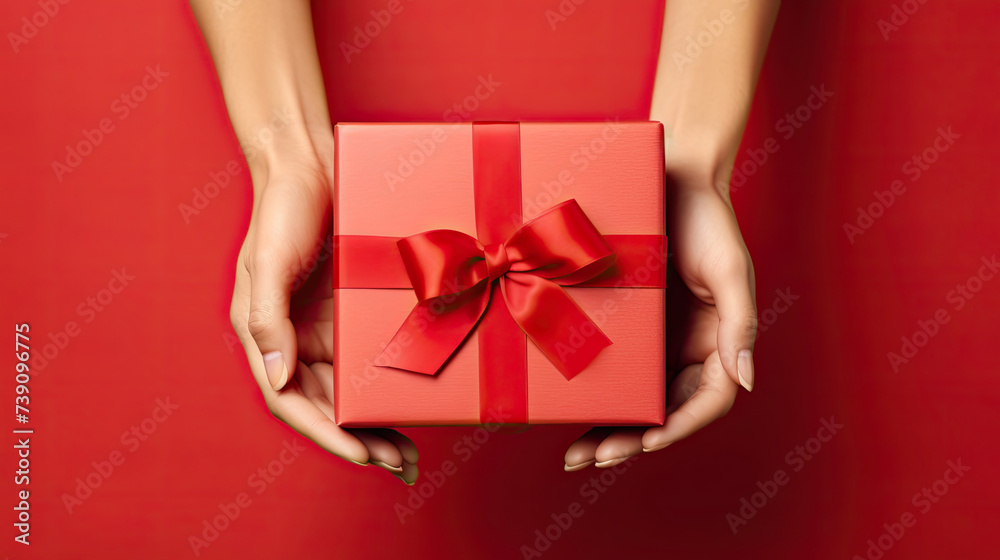 Woman's Hands Holding Luxury Gift Box Top View on Red Background Woman's Hands Holding Luxury Gift Box Top View on Red Background