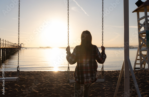 beautiful young woman on the swing on the sky background