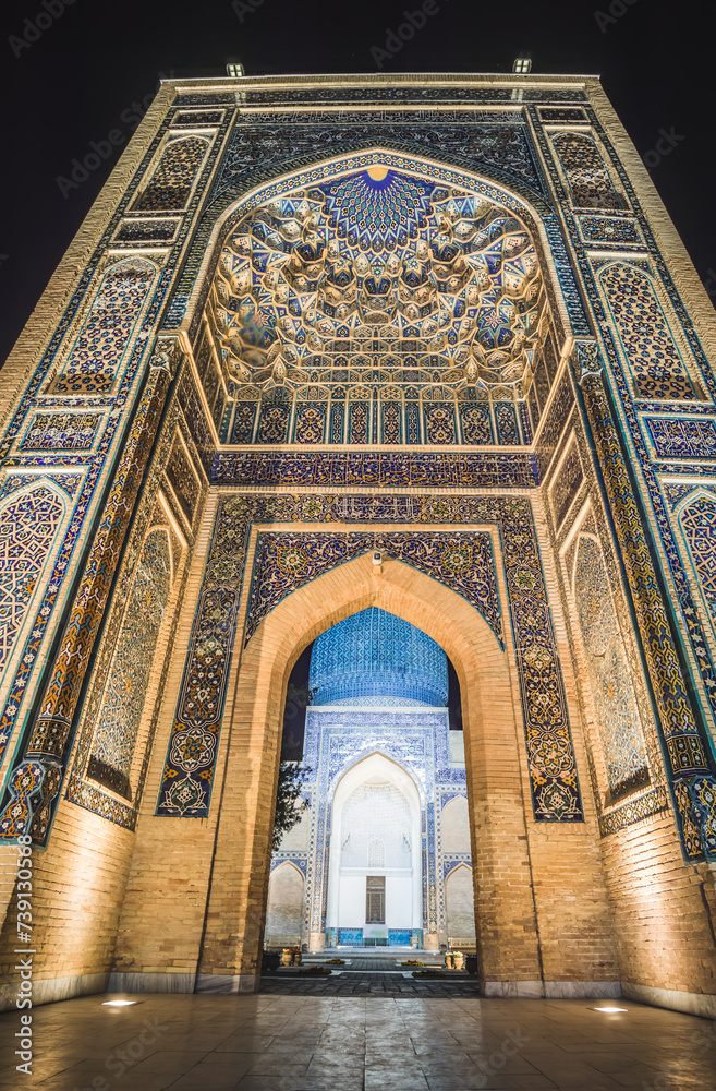 Facade of the Gur Emir mausoleum with mosaics and brick walls at night with illumination in the ancient city of Samarkand in Uzbekistan, oriental architecture in the evening Facade of the Gur Emir mausoleum with mosaics and brick walls at night with illumination in the ancient city of Samarkand in Uzbekistan, oriental architecture in the evening